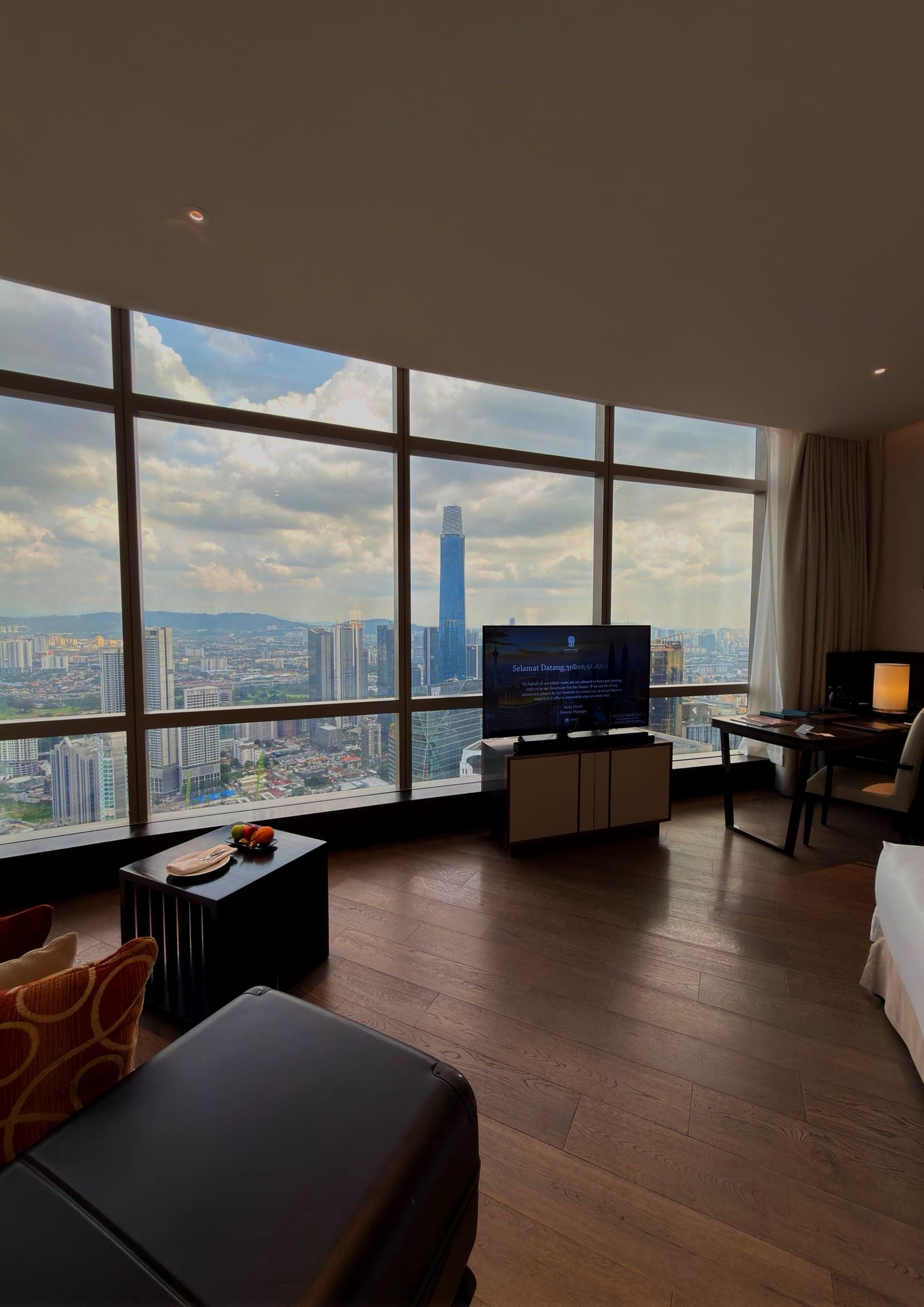 Floor-to-ceiling windows framing the Kuala Lumpur skyline from the room