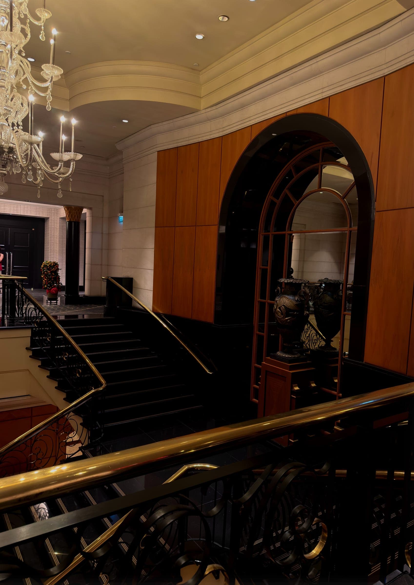 A grand black staircase beneath a crystal chandelier