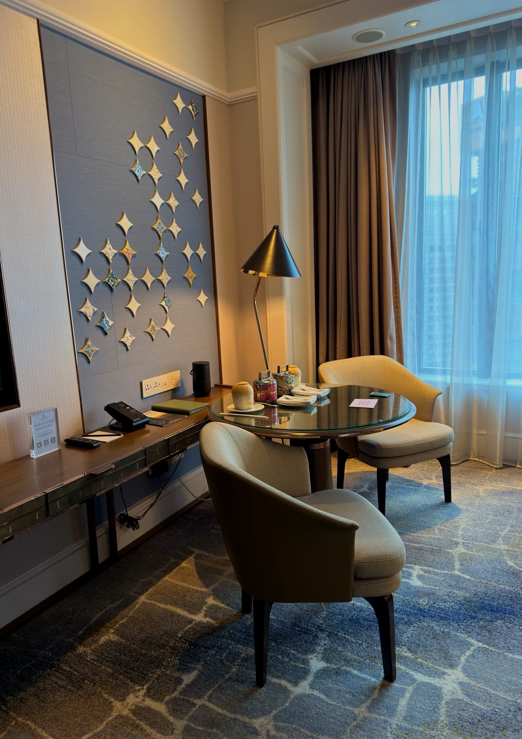 A writing desk and chairs beneath a wall of star-shaped mirrors
