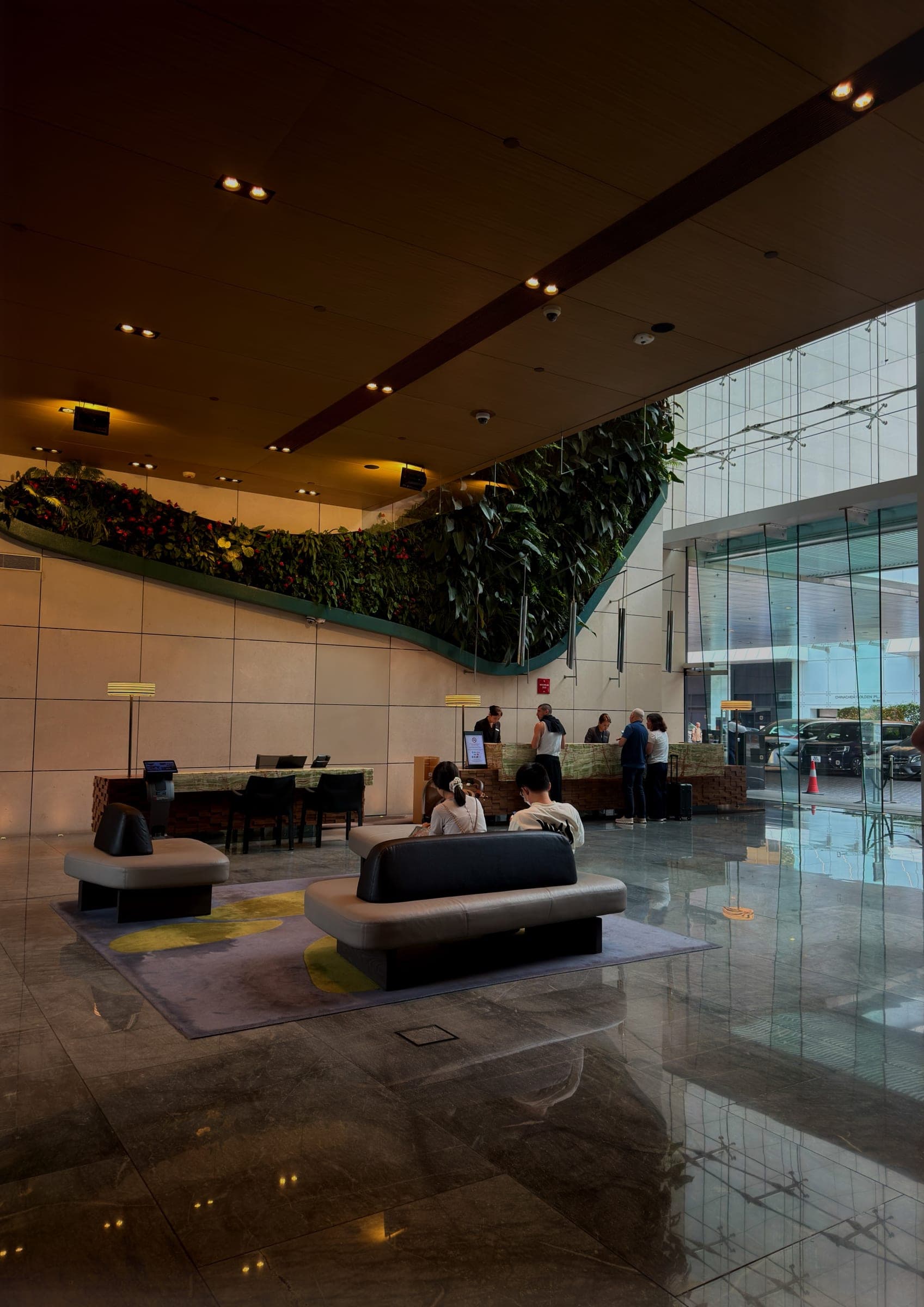 A hotel lobby beneath a sweeping vertical garden wall