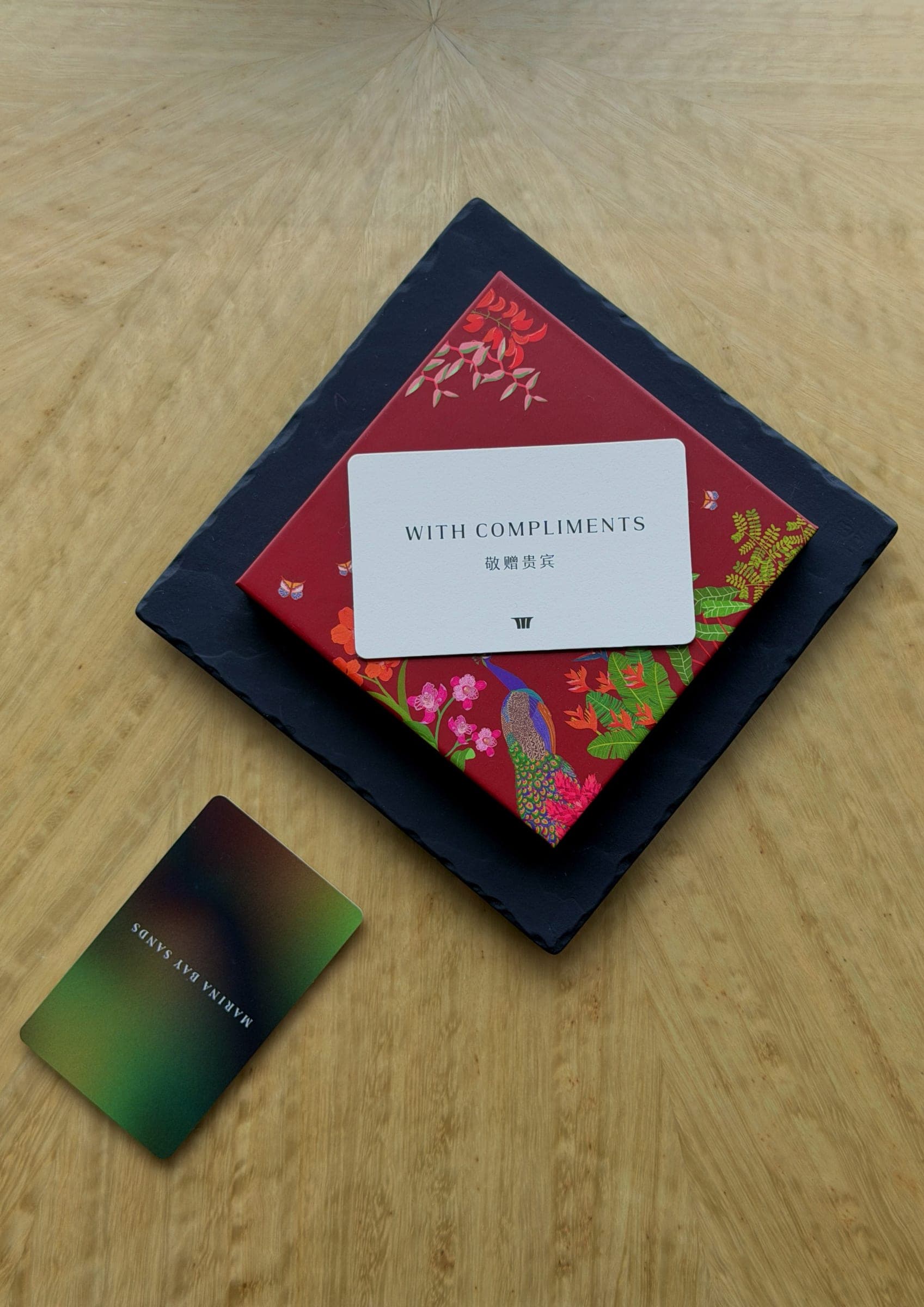 A handwritten with compliments card beside a Marina Bay Sands key