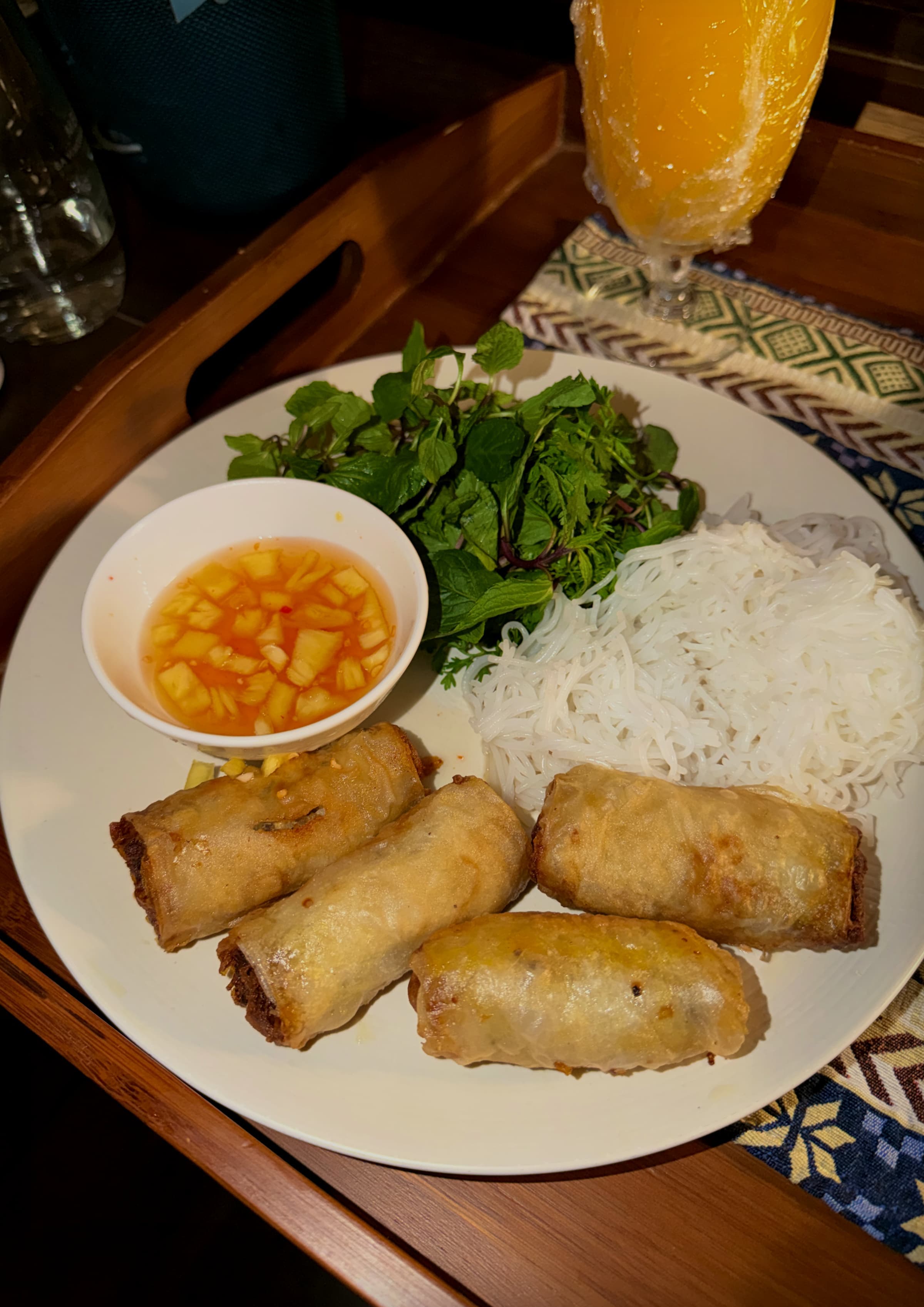 A plate of spring rolls and rice with a bowl of dipping sauce