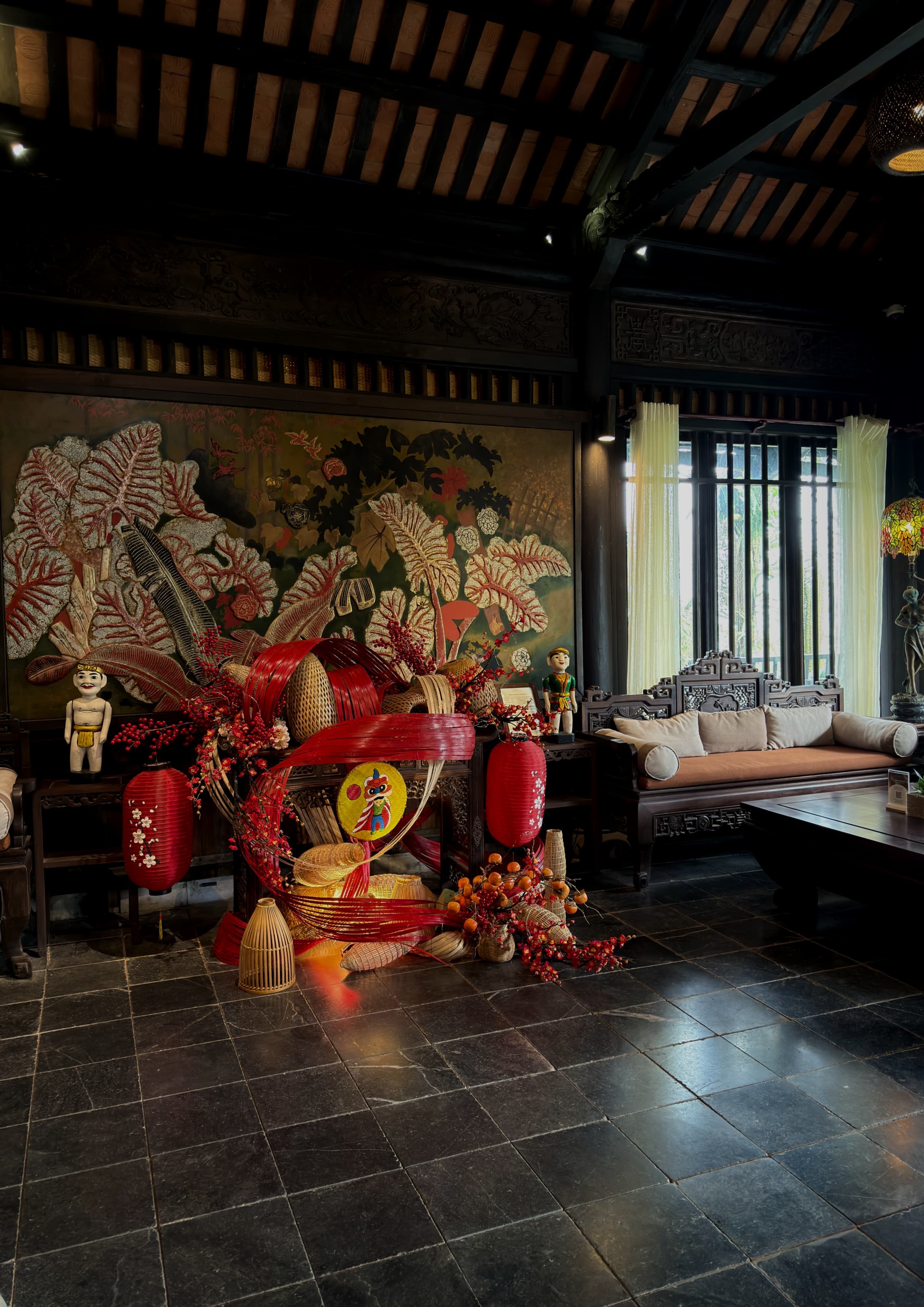 A dim lobby lounge with red decorative figures and a stone floor