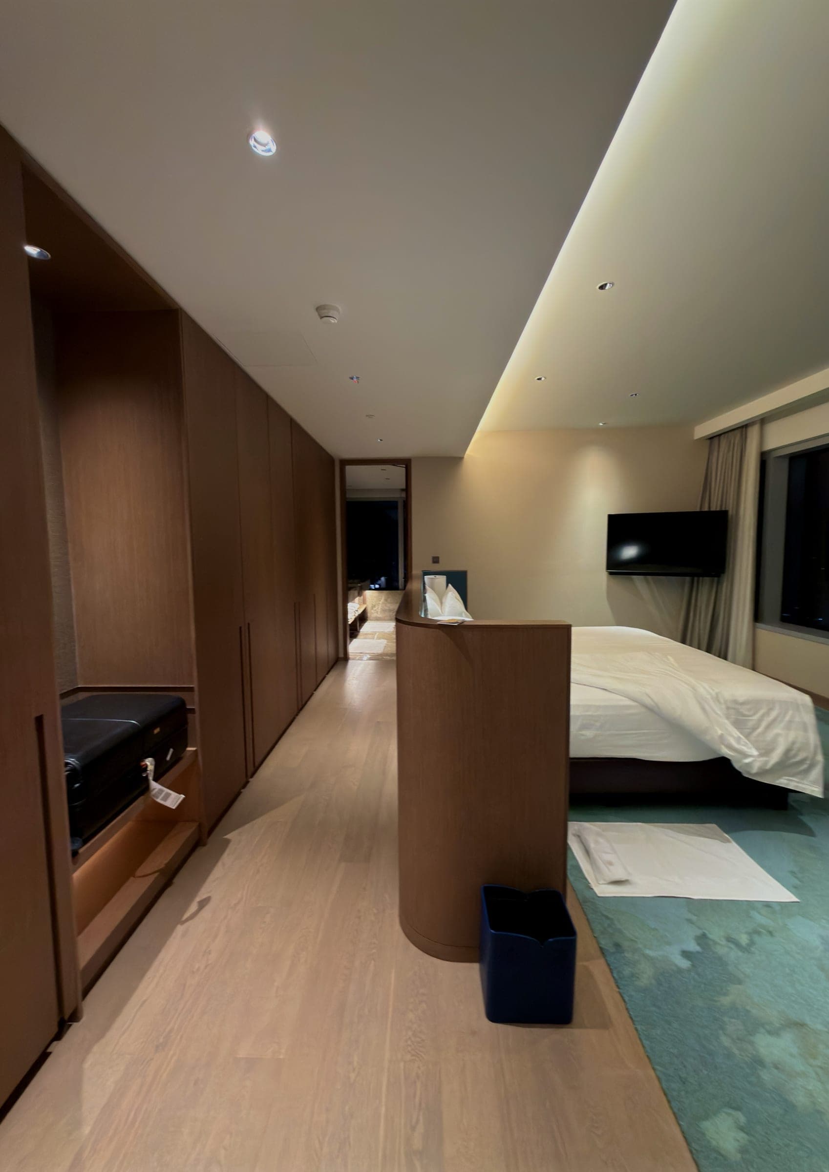 A junior suite with a long timber-lined dressing corridor leading to the bed