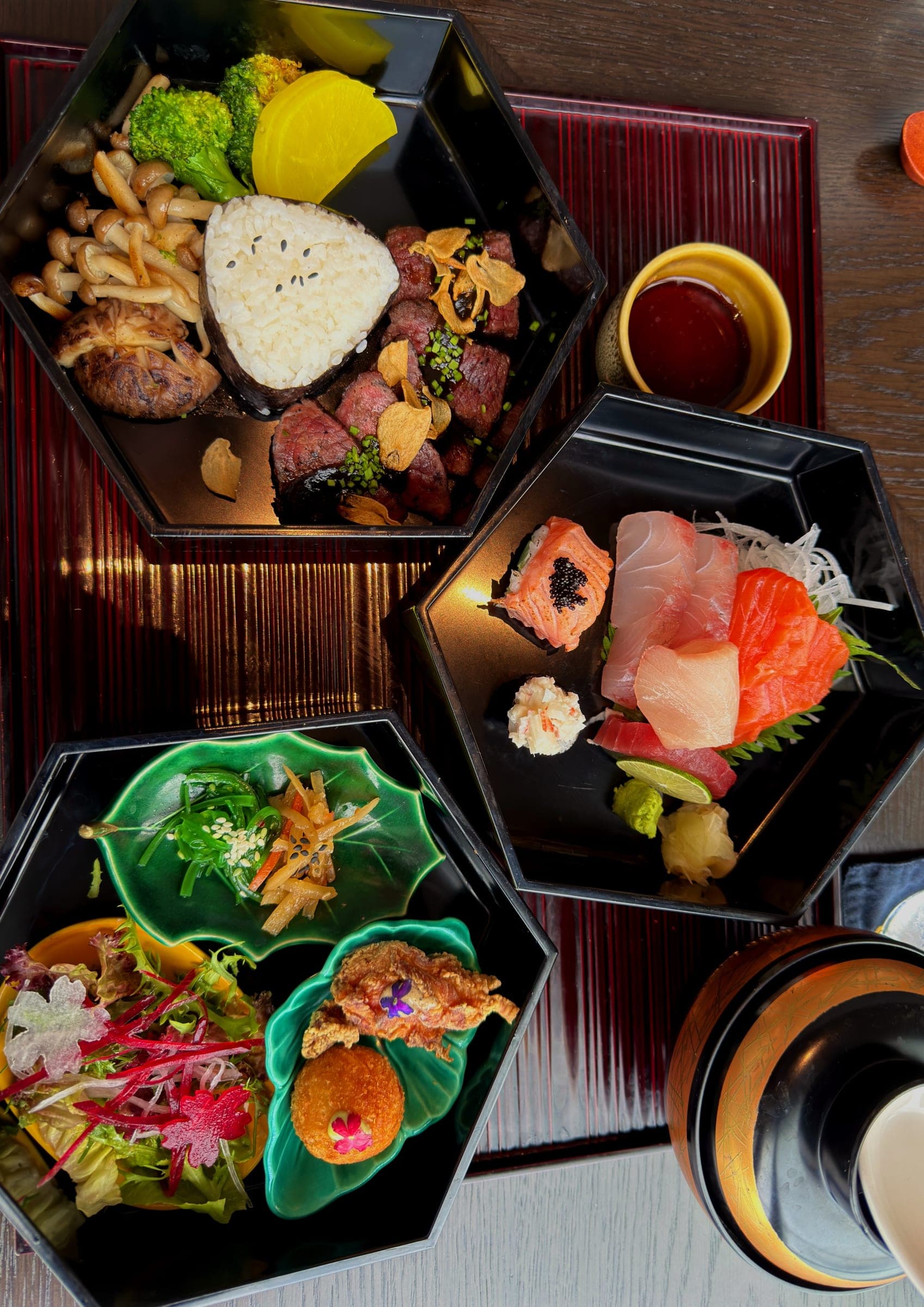 Hexagonal lacquer bento boxes of sashimi and small dishes