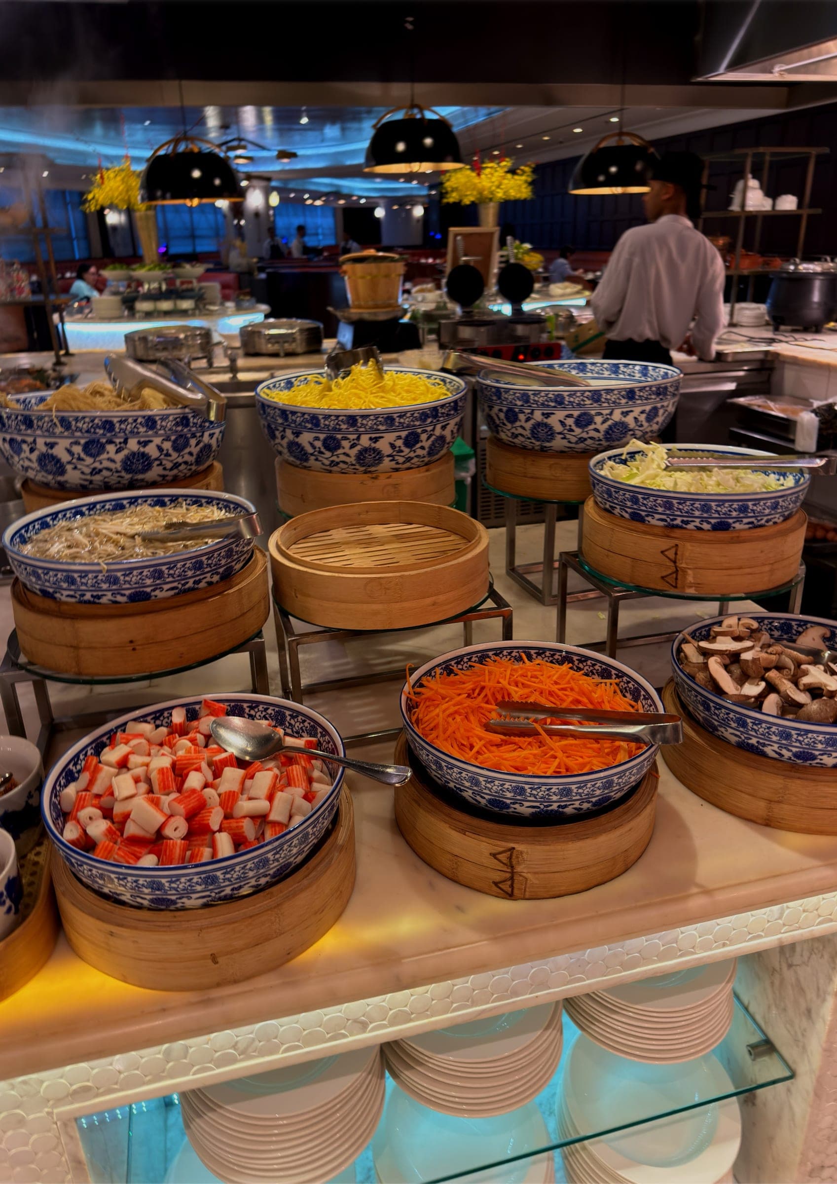A breakfast buffet with blue and white bowls and bamboo steamers